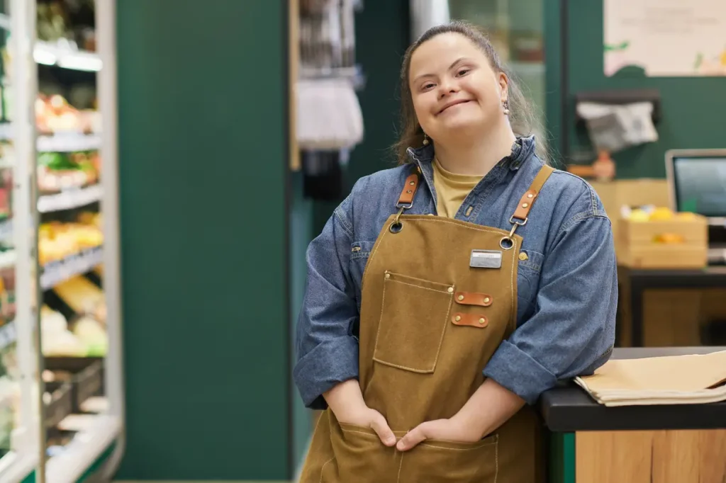 Confident disabled woman standing in a shop in her work uniform